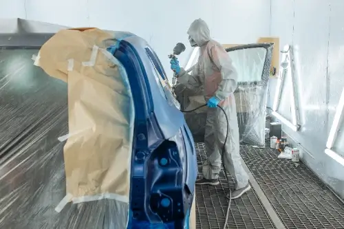 Painter spray painting a car