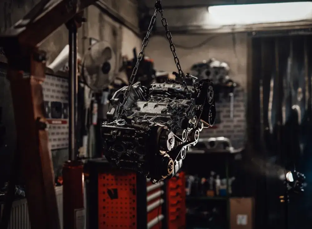 an engine suspended in a garage workshop