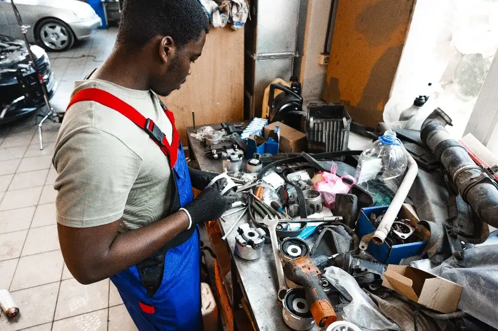 A mechanic looking at auto parts on table